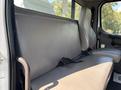 A gray bench seat in the cabin of a 2019 Freightliner M2 106 truck with seatbelts attached