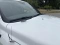 A white 2016 RAM 1500 truck hood with a roof-mounted lighting bar and a prominent antenna on the side