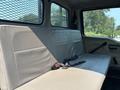 Interior view of a 2006 Sterling Acterra featuring a grey vinyl bench seat with seat belts and a metal mesh partition visible in the background