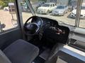 Interior view of a 2012 Ford Econoline showing the dashboard steering wheel and driver's seat with various controls and buttons
