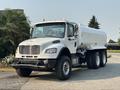 A white 2016 Freightliner M2 106 truck with a large tank body and six wheels is parked on a driveway
