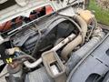 The engine compartment of a 2012 International 7400 showing various components including hoses, a coolant reservoir, and a large air filter housing