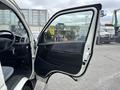 A 2009 Toyota Hiace with the driver's door open showing the interior features and seating area