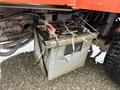 A gray and black battery with visible connections and wires attached, positioned under a Kubota F3680 agricultural vehicle.