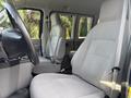 Interior view of a 2013 Ford E-350 Super Duty showing two gray cloth front seats and a steering wheel