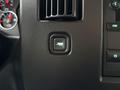 A close-up of a button in a 2021 Chevrolet Express dashboard featuring an icon of an open door