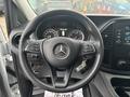 Steering wheel of a 2021 Mercedes-Benz Metris with controls and logo visible, dashboard displays visible behind the wheel