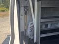 A 2019 Ford Transit 350 van with a shovel leaning against the interior wall and shelves for storage