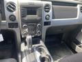 Interior view of a 2014 Ford F-150 showing the center console dashboard with controls and gear shifter along with cup holders