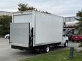 A white 2019 Ford Econoline box truck with a rear liftgate parked in a lot