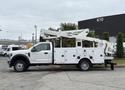 A 2018 Ford F-550 utility truck with a white exterior featuring side compartments and a mounted aerial lift on top