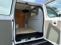 Interior of a 2013 Ford Econoline with wooden floor and partitioned area for cargo or equipment
