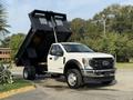 A 2022 Ford F-550 truck with a raised dump bed showcasing its construction and hauling capabilities
