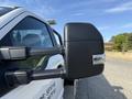 A close-up view of the side mirror of a white 2022 Ford F600 showcasing its sleek design and integrated light features