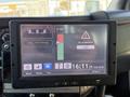 A digital display screen inside a vehicle showing a dashboard interface with information about driving status and time