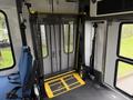 Interior view of a 2013 Chevrolet Express showing a folding wheelchair lift in position with a blue driver seat visible