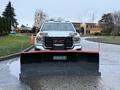 A 2017 GMC Sierra 3500HD equipped with a Hiniker snow plow positioned in the foreground ready for snow removal