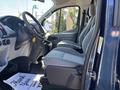 Interior view of a 2016 Ford Transit 150 showing the front seats and dashboard with a steering wheel and gear shift visible