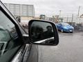 A 2019 Jeep Grand Cherokee's side mirror reflecting part of the vehicle and a nearby car