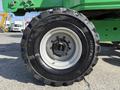 Close-up view of a large tire mounted on a green 2015 JLG 450AJ aerial lift showing the tread patterns and wheel rim