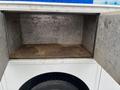 An empty storage compartment of a 2012 Workhorse W62 with metal walls and a dirty floor