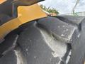 Close-up of a large tire from a 2012 Caterpillar 980 featuring deep treads and a worn surface indicating heavy use