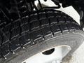 Close-up of a 2015 Ford F-450 tire showcasing deep treads and a shiny wheel rim