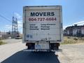 A 2014 Hino 195 moving truck with the word "MOVERS" prominently displayed on the back along with a phone number and service details
