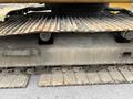 Close-up of the undercarriage of a 2018 John Deere 350 featuring metal tracks and a textured surface with visible wear and dirt
