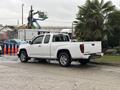 A white 2011 Chevrolet Colorado truck parked with a closed bed and chrome accents