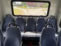 Interior view of a 2017 Chevrolet Express showing several blue upholstered seats arranged in a row with seatbelts