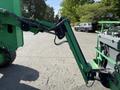 A green JLG 450AJ aerial lift with an extended arm and basket attachment is shown in the foreground