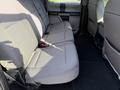The image shows the rear interior seating of a 2021 Ford F-250 SD with two bench seats covered in light gray fabric