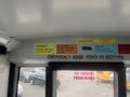 Interior view of a 2007 Freightliner B2 bus showcasing motivational signs on the ceiling with an emergency exit sign above the door