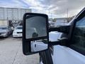 Side mirror of a white 2008 Ford F-450 showing a partial reflection of the vehicle and surroundings