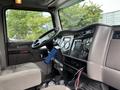 Interior view of a 2013 Kenworth T370 truck featuring a steering wheel dashboard gauges and an electronic display mounted on the center console