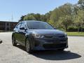 A blue 2018 Kia Rio5 hatchback is parked with a sleek design and modern front grille showcasing its stylish features