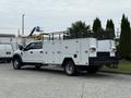 A 2020 Ford F-550 with a white service body features multiple storage compartments and a black grid panel on the back
