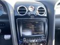 The interior dashboard of a 2015 Bentley Continental GT featuring a control panel with a display screen and air vents