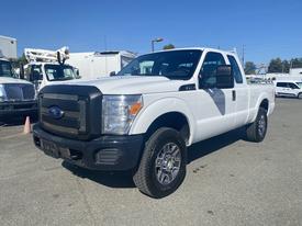 A white 2014 Ford F-250 Super Duty with a black grille and chrome accents parked with its front angled towards the viewer and a double cab configuration