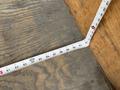 A measuring tape extended on a wooden surface with numbers visible from 80 to 90