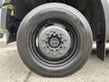 Close-up of a black wheel and tire from a 2010 Ford F-550 Super Duty focusing on the tire tread and the wheel rim design