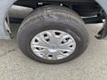 A close-up of a silver hubcap with a blue Ford logo attached to a black tire on a 2024 Ford Transit