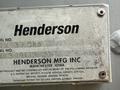 A weathered metal plate displaying the name "Henderson" along with "HENDERSON MFG INC MANCHESTER IOWA" and several patent numbers