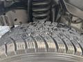 A close-up of a tire from a 2008 Ford Econoline displaying detailed tread patterns and small debris lodged in the grooves
