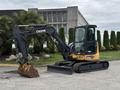 2017 John Deere 50G compact excavator featuring a black and yellow exterior a large digging bucket and a shaded operator cab with tracks for maneuverability