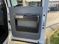 The image shows the interior door panel of a 2014 Ford F-550 featuring a gray design with a handle and storage compartment