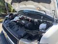 A 2020 Chevrolet Express with its hood raised showcasing the engine compartment including various components and hoses