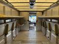 A 2012 Ford E-450 Super Duty with a spacious interior featuring metal shelving units and an open cargo area
