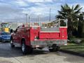A red 2013 Chevrolet Silverado 3500HD with a utility bed and ladder racks on the rear is parked with its back facing the viewer